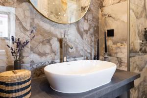 La salle de bains est pourvue d'un lavabo blanc et d'un miroir. dans l'établissement Brand New Old Town Apartment With Terrace, à Haapsalu