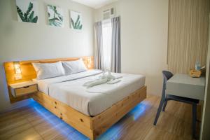 Schlafzimmer mit einem Bett, einem Schreibtisch und einem Stuhl in der Unterkunft DLT Suites Boutique Hotel in Minglanilla