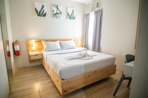 ein Schlafzimmer mit einem Bett mit einem Teddybär drauf in der Unterkunft DLT Suites Boutique Hotel in Minglanilla