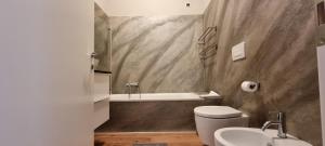 ein Badezimmer mit einer Badewanne, einem WC und einem Waschbecken in der Unterkunft DV Garda Suite in Campione del Garda