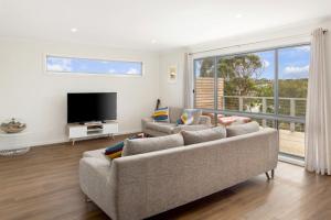 een woonkamer met 2 banken en een flatscreen-tv bij 187 Smiths Beach Road Smiths Beach in Smiths Beach