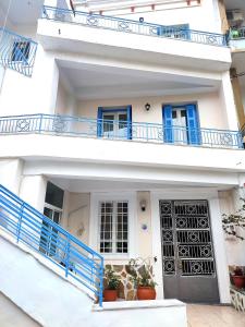 a white house with blue balconies and a door at ASTY in Mytilene