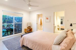 a bedroom with a bed and a large window at Celeste 26 Bonito Street light filled pet friendly house in Corlette