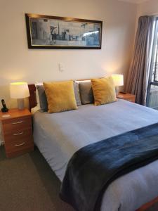 a bedroom with a bed with two lamps and a picture on the wall at ASURE Ascot Motor Inn in Taupo