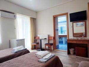 a hotel room with two beds and a television at ASTY in Mytilene