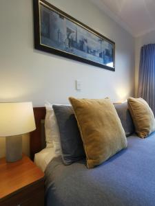 - une chambre dotée d'un lit avec des oreillers et une photo sur le mur dans l'établissement ASURE Ascot Motor Inn, à Taupo
