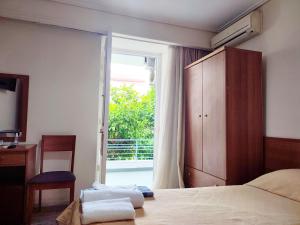 a bedroom with a bed and a sliding glass door at ASTY in Mytilene