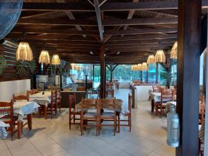 a dining room with tables and chairs and chandeliers at Amari Hotel in Metamorfosi