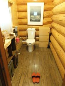 a bathroom with a toilet and a pair of slippers at 登別市ログハウス in Noboribetsu