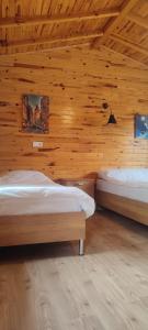 sypialnia z 2 łóżkami w drewnianej ścianie w obiekcie Yolda Bungalow Cafe w mieście Kumluca
