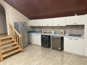 uma cozinha com armários brancos e uma máquina de lavar roupa em Mtskheta Wellpoint Arsukidze 48 em Mtskheta