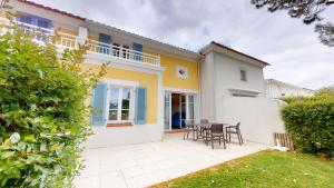 een huis met stoelen en een tafel in een tuin bij Le Cottage des Fontenelles in Coëx