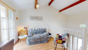 een woonkamer met een stoel en een wieg bij Le Cottage des Fontenelles in Coëx +32 foto's