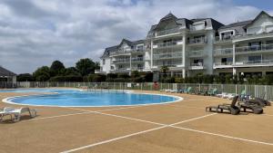 een groot gebouw met een zwembad voor een gebouw bij Le Cottage des Fontenelles in Coëx