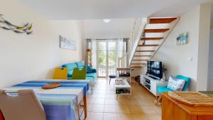 een woonkamer met een bed en een trap bij Le Cottage des Fontenelles in Coëx