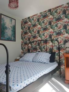 sypialnia z łóżkiem i tapetą w kwiaty w obiekcie TY BIHAN w mieście La Bernerie-en-Retz