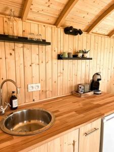 una cocina con fregadero en una cabaña de madera en Roulotte „douceur“ en Condom