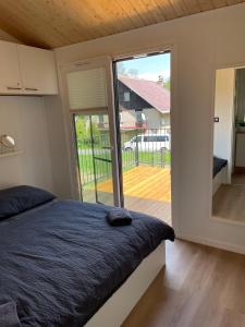 een slaapkamer met een bed en een grote glazen schuifdeur bij Samostatný domek SRDCOVKA in Dolní Morava