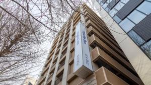熊本市にある東横INN熊本桜町バスターミナル前の時計付きの高層ビル +32枚の写真