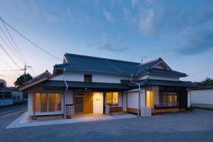 una casa japonesa con techo negro en FARMSTAY miyuki-street "Goen", en Ukiha