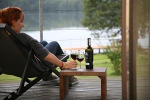 a woman sitting in a chair with a glass of wine at Siedlisko Kłodno in Sulęczyno
