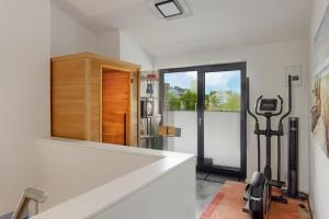 a room with a treadmill next to a kitchen at Stressless in Heiligenhafen
