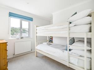 ein Schlafzimmer mit einem Etagenbett und einem Fenster in der Unterkunft Fairwinds in Portreath