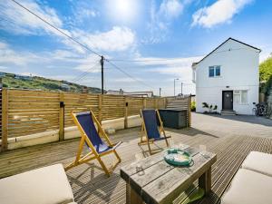 a patio with two chairs and a table on a deck at Fairwinds in Portreath