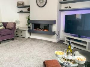 a living room with a fireplace and a tv at No 1 Overman in Bowburn