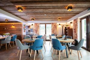 un comedor con mesas y sillas azules en Timian Chalet en Miercurea-Ciuc