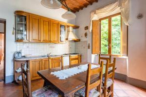 een keuken met een houten tafel en een tafel en stoelen bij Casale Poli in Borgo a Mozzano