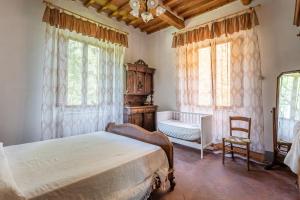 sypialnia z łóżkiem, krzesłem i oknami w obiekcie Casale Poli w mieście Borgo a Mozzano