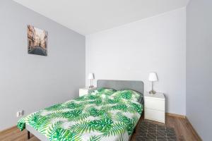 1 dormitorio con 1 cama con manta verde y blanca en Luxury in City-6- Free Parking, en Łódź