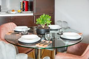 einem Esstisch mit Tellern und einer Pflanze darauf in der Unterkunft Stunning Apartment with Underground parking! in London