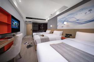 a hotel room with two beds and a flat screen tv at Yiwu Boyi Meiju Hotel义乌市泊忆酒店 in Yiwu