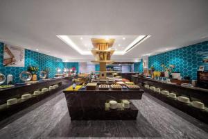 una línea de buffet en un restaurante con azulejos azules en Yiwu Boyi Meiju Hotel义乌市泊忆酒店 en Yiwu