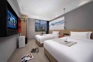 義烏市にあるYiwu Boyi Meiju Hotel义乌市泊忆酒店のベッド2台、薄型テレビが備わるホテルルームです。