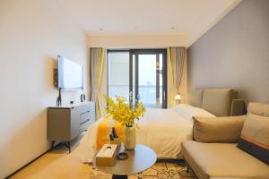 Habitación de hotel con cama y sofá en Canopy Executive Apartments - Shenzhen Futian Center en Shenzhen