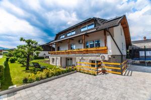 a large house with a patio in front of it at Apartments Ursus in Bled