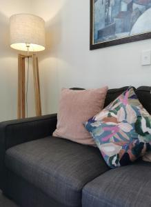 a couch with a pillow and a lamp in a living room at ASURE Ascot Motor Inn in Taupo