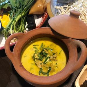 a wooden bowl of soup with vegetables in it at Maewin Guest House and Resort in Ban Huai Rin