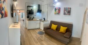 Una sala de estar con un sofá y una cocina. en Casa Via De La Plata, en Cáceres