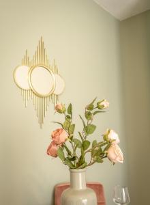 un vaso con fiori in una stanza con un muro di Koulas luxury apart by homebrain a Alexandroupoli