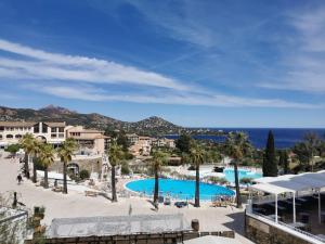 widok na basen w ośrodku z palmami w obiekcie APPARTEMENT CAP ESTEREL CLIMATISE VUE MER w mieście Agay - Saint Raphael
