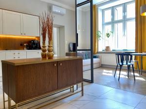 cocina con armario de madera y comedor en Faust Apartments in the Heart of Kazimierz, en Cracovia