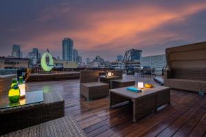 a rooftop deck with tables and chairs and a city skyline at CityNote Hotel - Guangzhou Beijing Road Sun Yatsen Memorial Hall Metro Station in Guangzhou