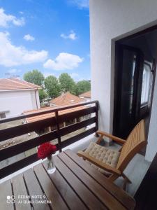 a balcony with a bench and a vase of flowers at Уютна къща in Sliven