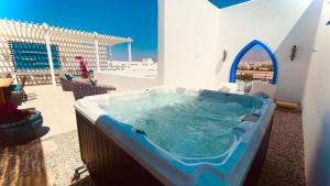 a hot tub in a room with a patio at Cloud 7 Residences Ayla Aqaba in Aqaba