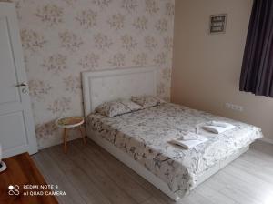 een slaapkamer met een bed met twee handdoeken erop bij Уютна къща in Sliven