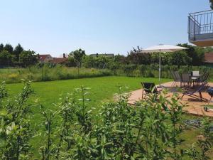 a lawn with an umbrella and a table and chairs at 3 Meeresperlen Strandhaus in Groß Schwansee